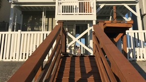 A multi-story building with a wooden deck and white railings.
