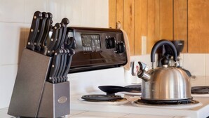 A kitchen with a modern stove, a kettle, and a knife block. - Moonraker -Oceanfront, balcony, kitchen, fireplace (Lincoln City)