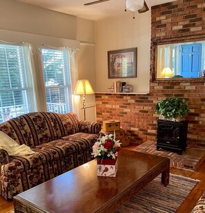 A living room with a sofa, a coffee table, a fireplace, and a bookshelf.