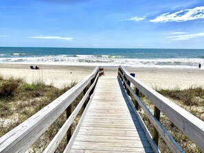 A wooden boardwalk leading to a sandy beach with the ocean in the background. - "The Sea Shack" Cottage Feet to Sand (Carolina Beach)