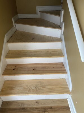 Una escalera con escalones de madera y detalles blancos.