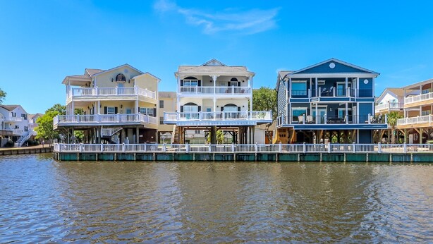 A waterfront property with multiple balconies and a dock extending into the water. - LAKEFRONT, 5 BDRM, Ocean View! Quiet. Fish off deck. Just reduced Aug wks! (Myrtle Beach)