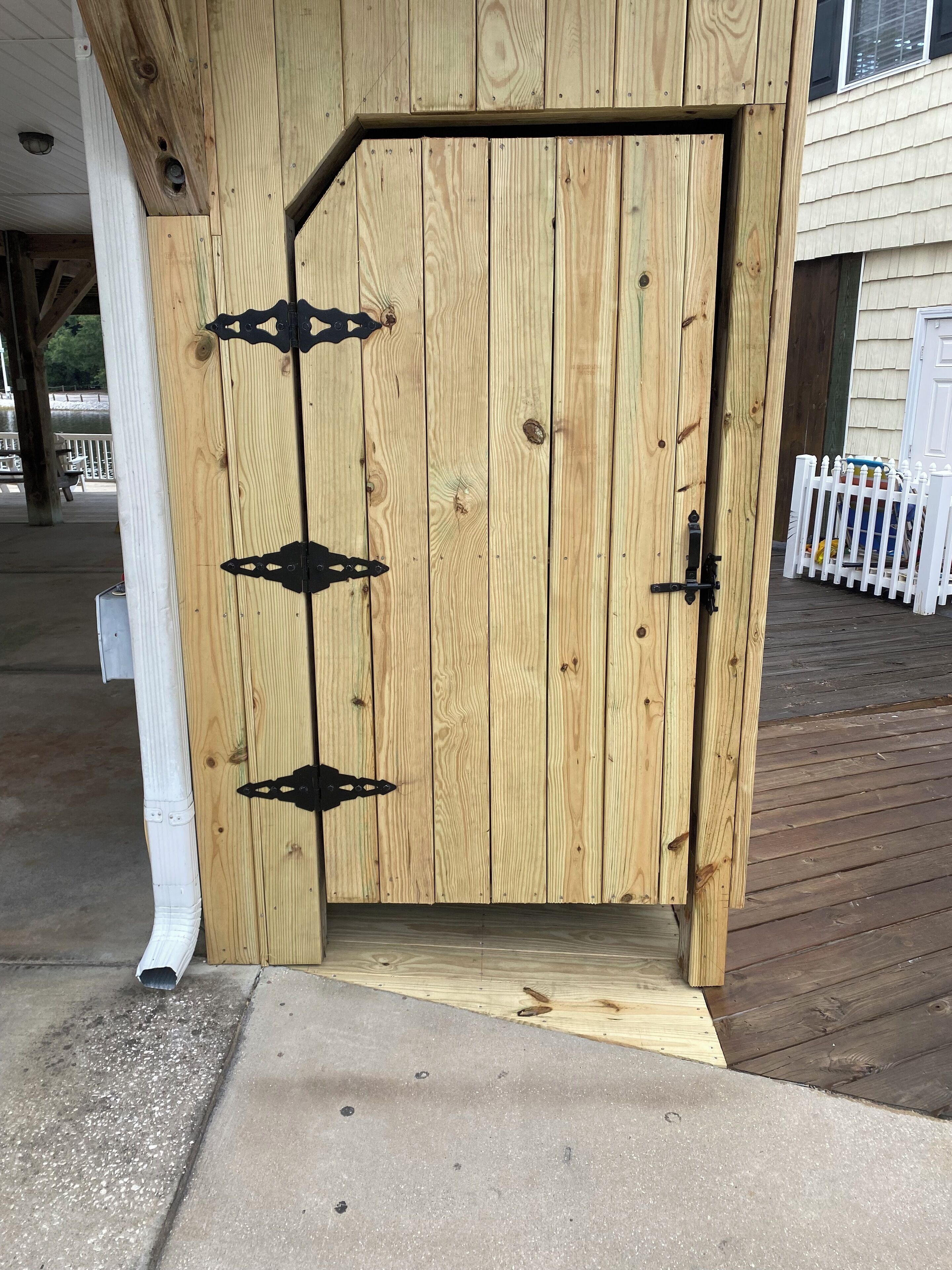A wooden door with a metal latch and a small step leading up to it.