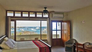 A hotel room with a large window offering a view of boats at a marina. - Galeodan Bonito Suite - your home In Paradise (Puerto Baquerizo Moreno)
