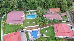 A residential area with multiple houses, a swimming pool, and lush greenery. - Sithi Villas (Hikkaduwa)
