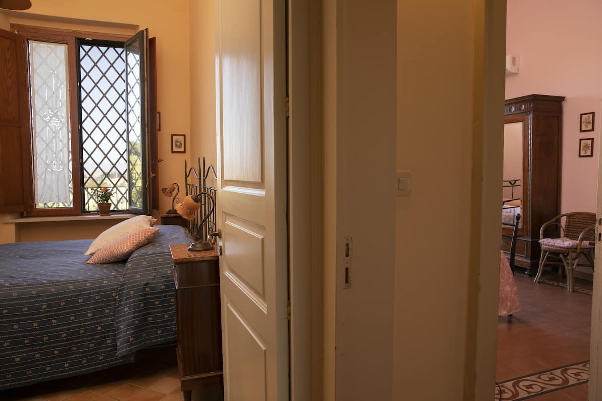 Un dormitorio con cama, ventana con vistas, cómoda y una silla.
