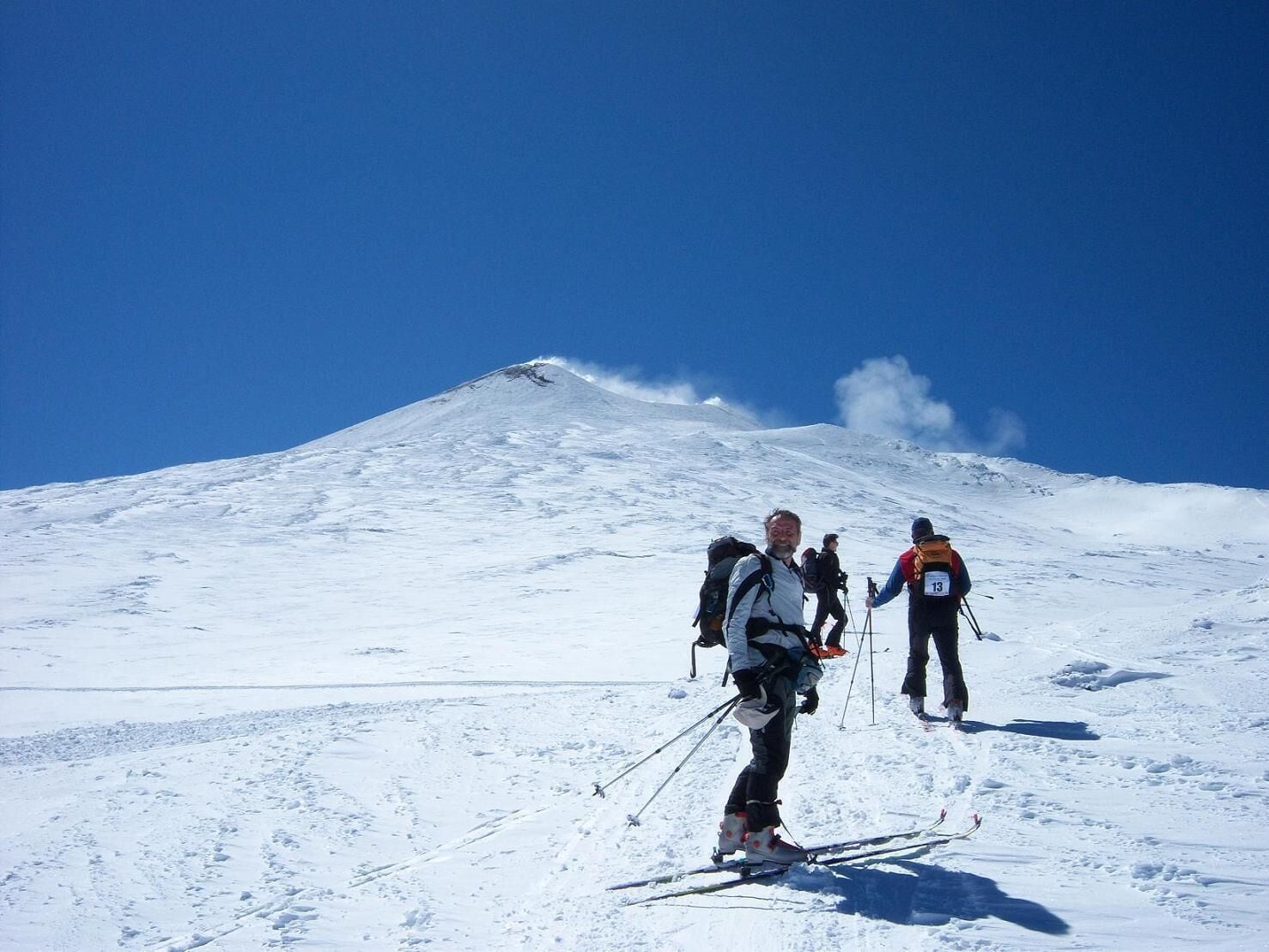 A snowy mountain with skiers.
