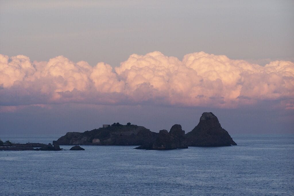A coastal landscape with rocky formations and calm sea.