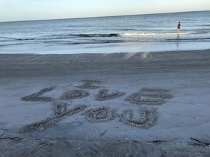 A beach with the words "Love You" written in the sand.