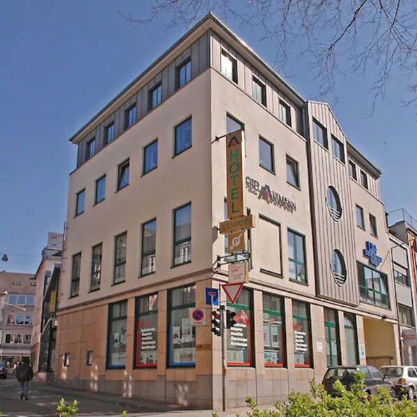 A multi-story hotel with a modern facade, large windows, and a visible sign indicating hotel services. - Hotel Aulmann (Trier)