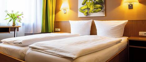 A hotel room with two beds, a painting of a frog, and two wall lamps.
