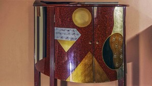 Un mueble con diseños geométricos y una ventana encima.