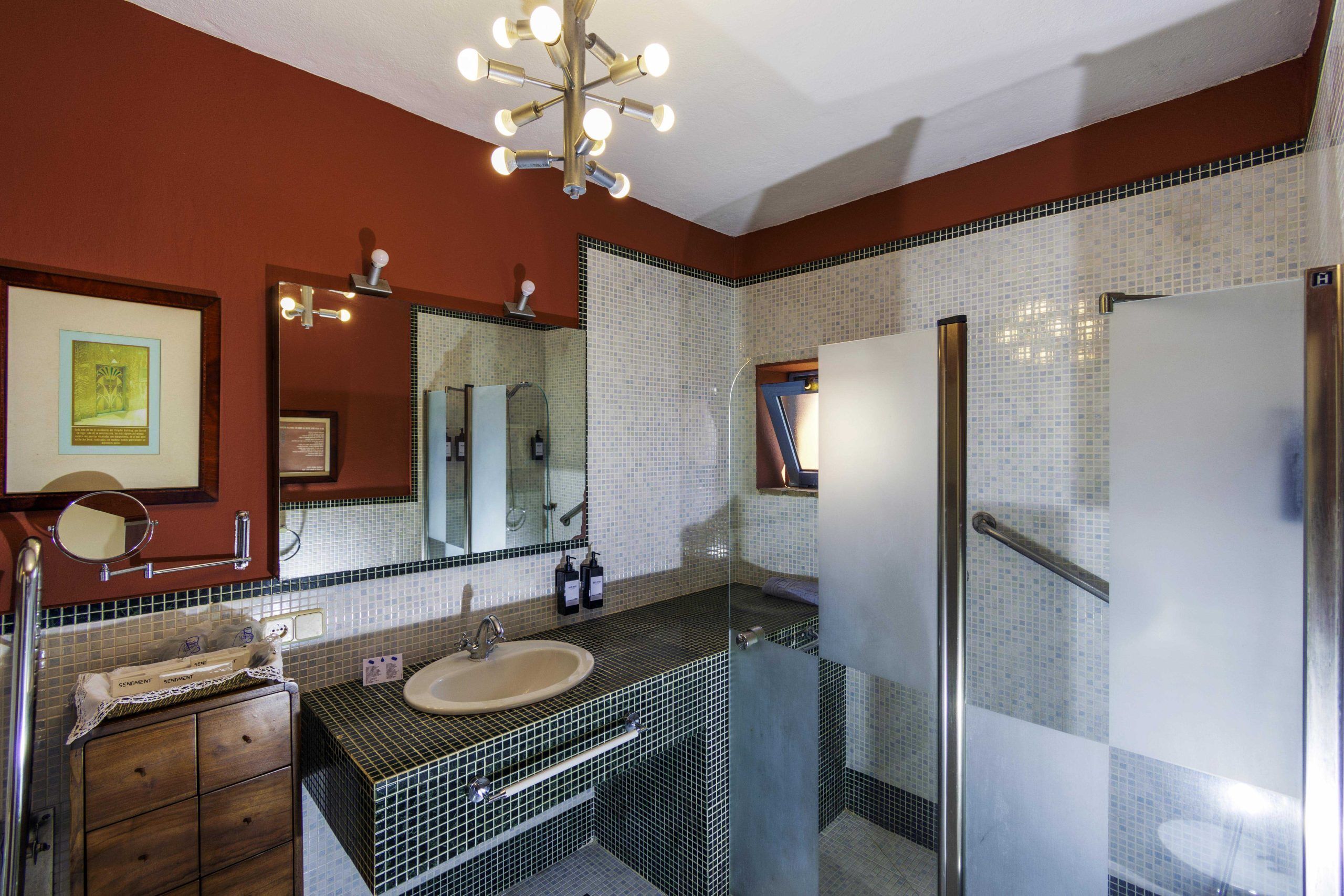 A bathroom with a sink, mirror, and tiled walls.