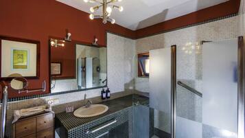 Un baño con lavamanos, espejo y paredes con azulejos.