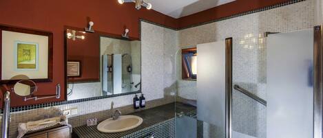 A bathroom with a sink, mirror, and tiled walls.