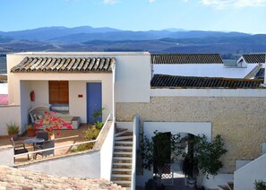 Un edificio residencial con patio, una escalera y vistas a montañas distantes.