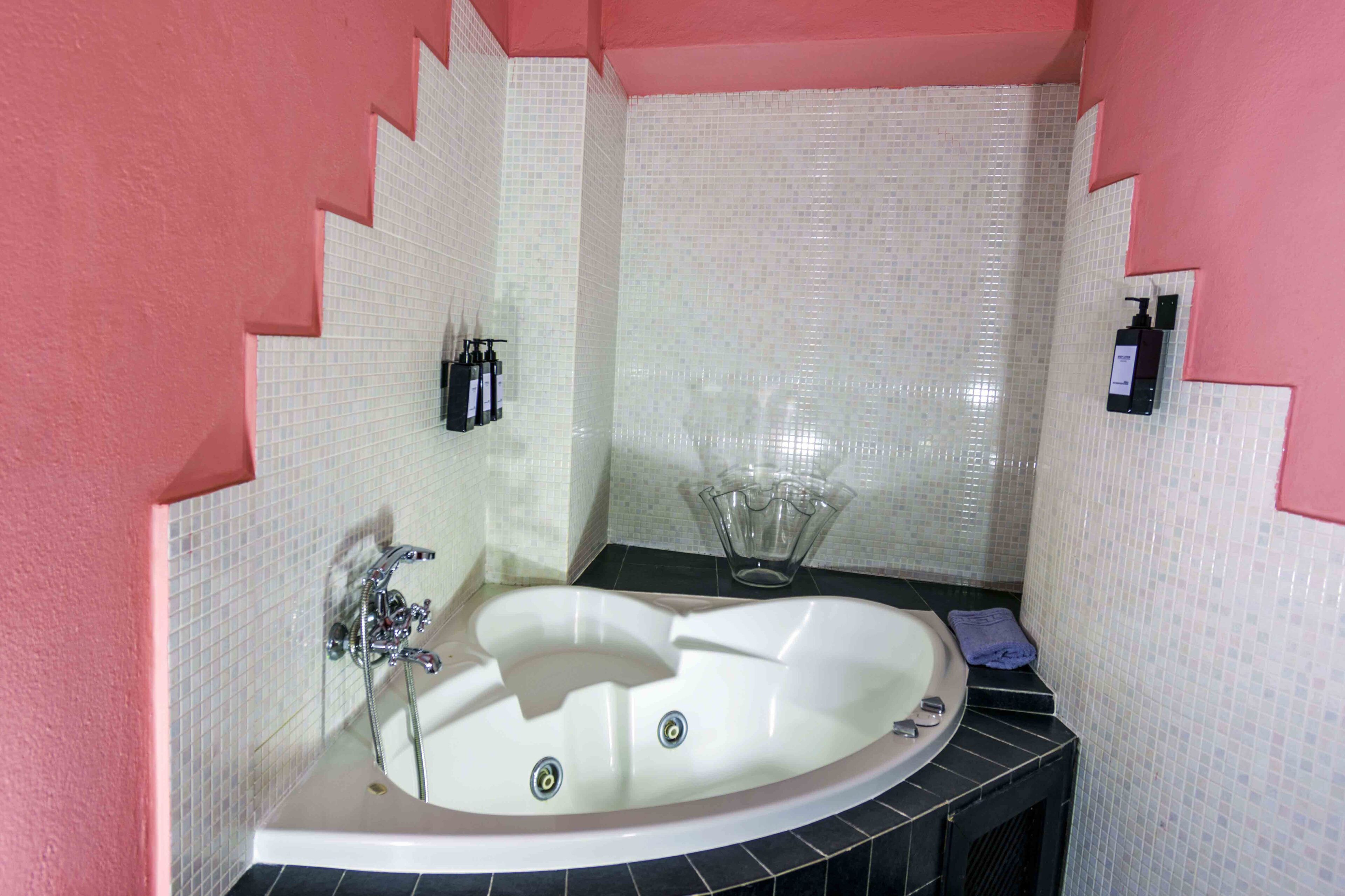A bathroom with a large bathtub, a shower, and a sink.