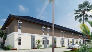 A modern building with a flat roof, multiple windows, and a car parked in front. - Executive Lofts by Mystique Lane (Bacolor)