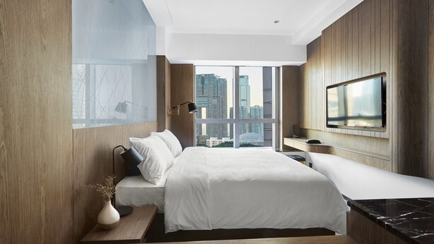 A modern hotel room with a large bed, a TV mounted on the wall, and a city view through the window. - The Otto Hotel (Kowloon)