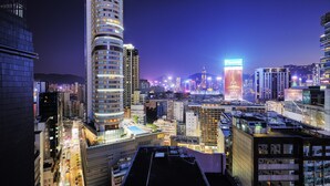 A high-rise building with a curved facade and multiple floors, surrounded by other tall buildings in a cityscape. - The Otto Hotel (Kowloon)