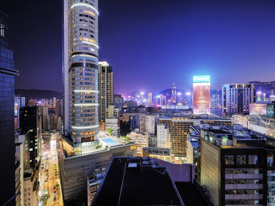 A high-rise building with a curved facade and multiple floors, surrounded by other tall buildings in a cityscape.