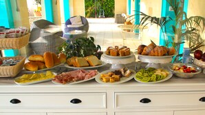 A buffet table with various food items including bread, pastries, fruits, and vegetables. - Tenuta Donna Caterina (Mesagne)