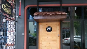 Una puerta de madera con un letrero que dice "The 25 Hostel" y el número "25".