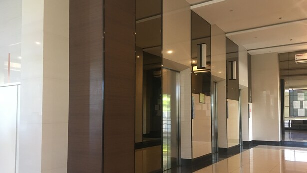 Un interior moderno con suelos reflectantes, divisiones de vidrio y un diseño limpio y minimalista.
