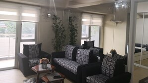 Una sala de estar con un sofá, una mesa de centro y un espejo grande.