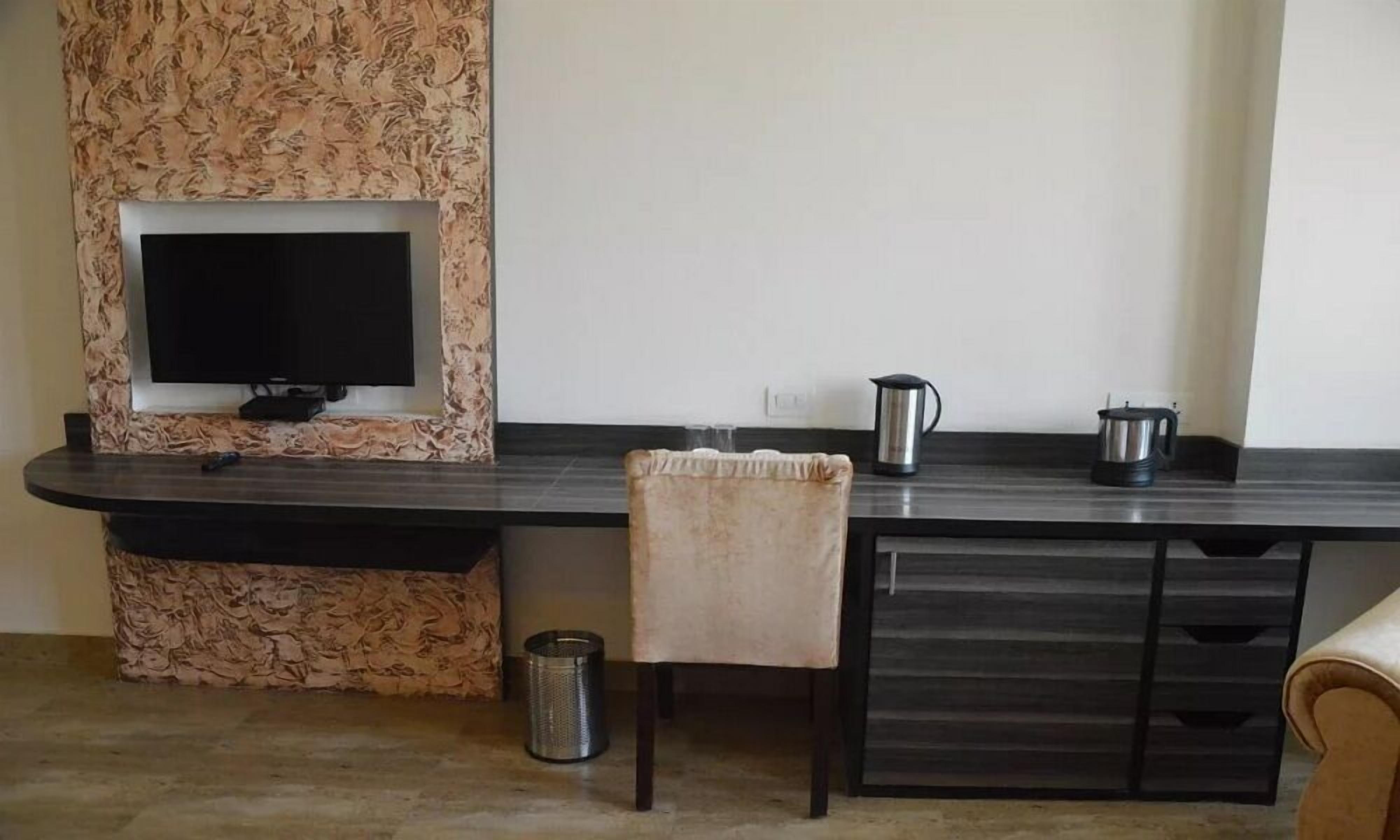 A modern kitchen with a built-in TV, a coffee maker, and a trash can.
