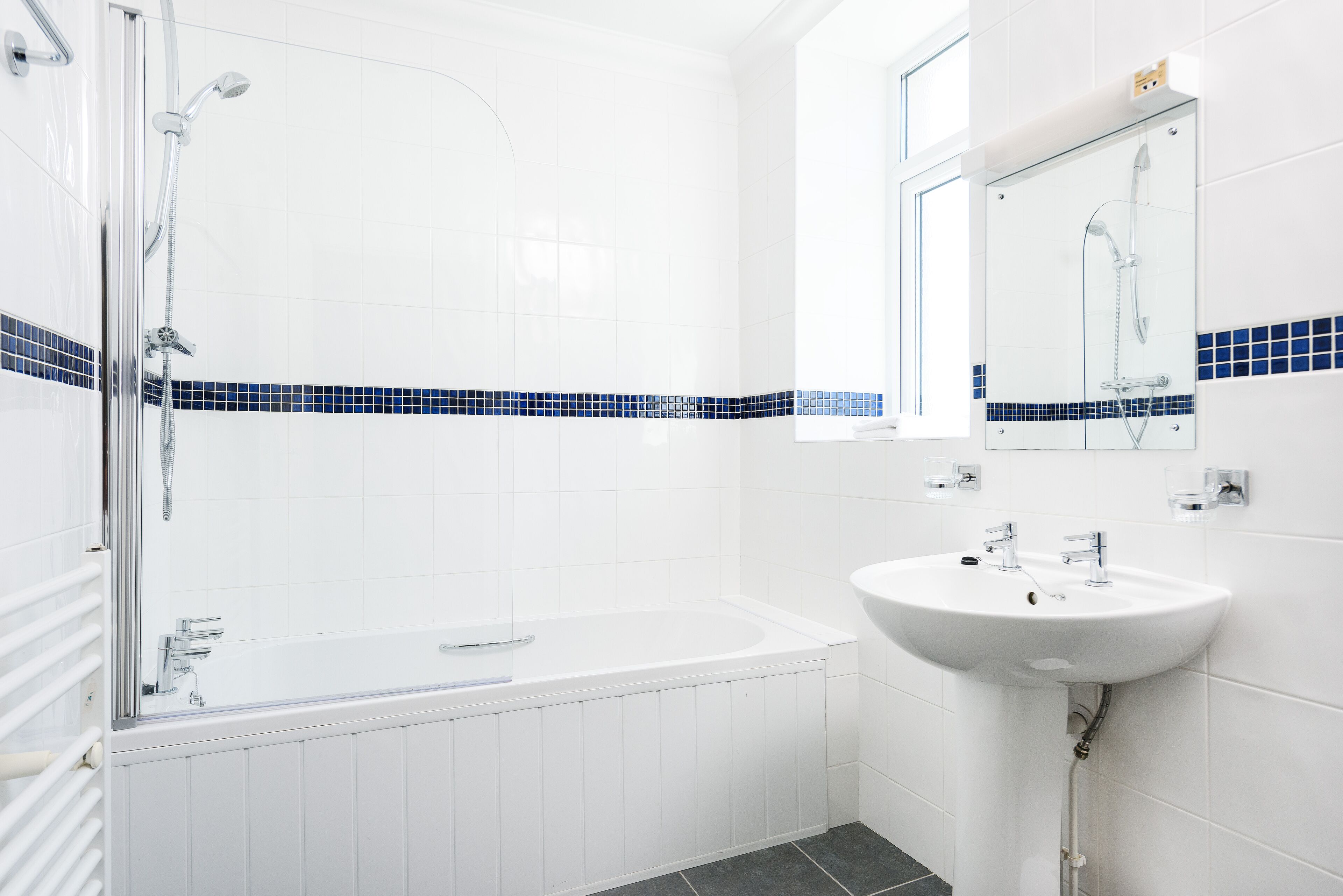 A modern bathroom with a bathtub, a sink, and a glass-enclosed shower area.