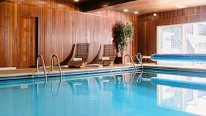 A swimming pool with wooden paneling, lounge chairs, and a potted plant. - Kilbirnie Hotel (Newquay)