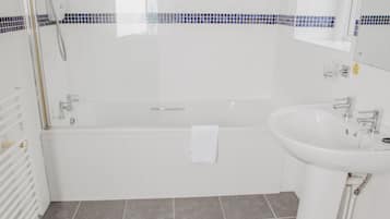 Un baño moderno con bañera, lavamanos e inodoro.