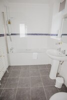 Un baño moderno con bañera, lavamanos e inodoro.