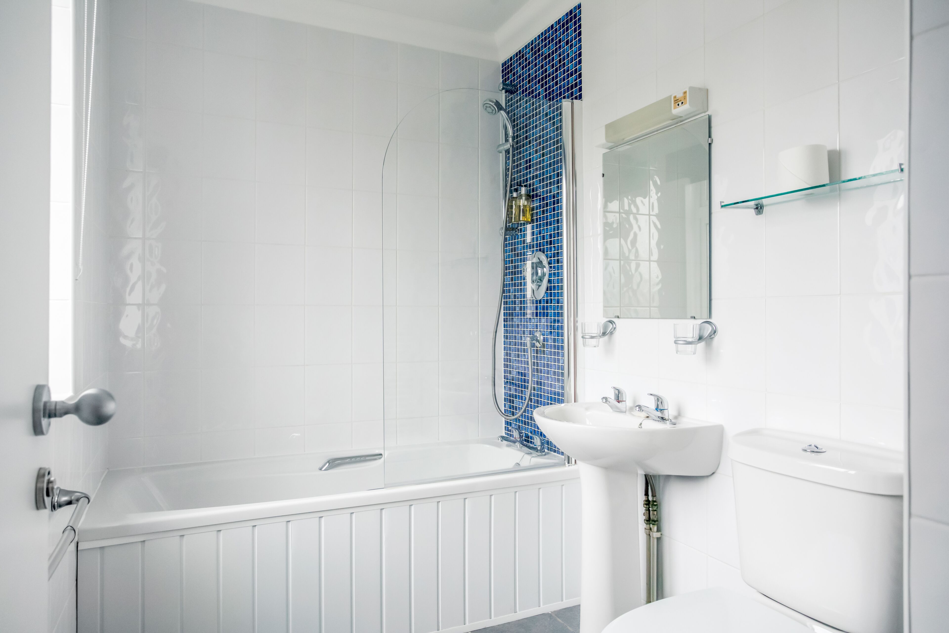A modern bathroom with a bathtub, a glass shower enclosure, a sink, and a toilet.