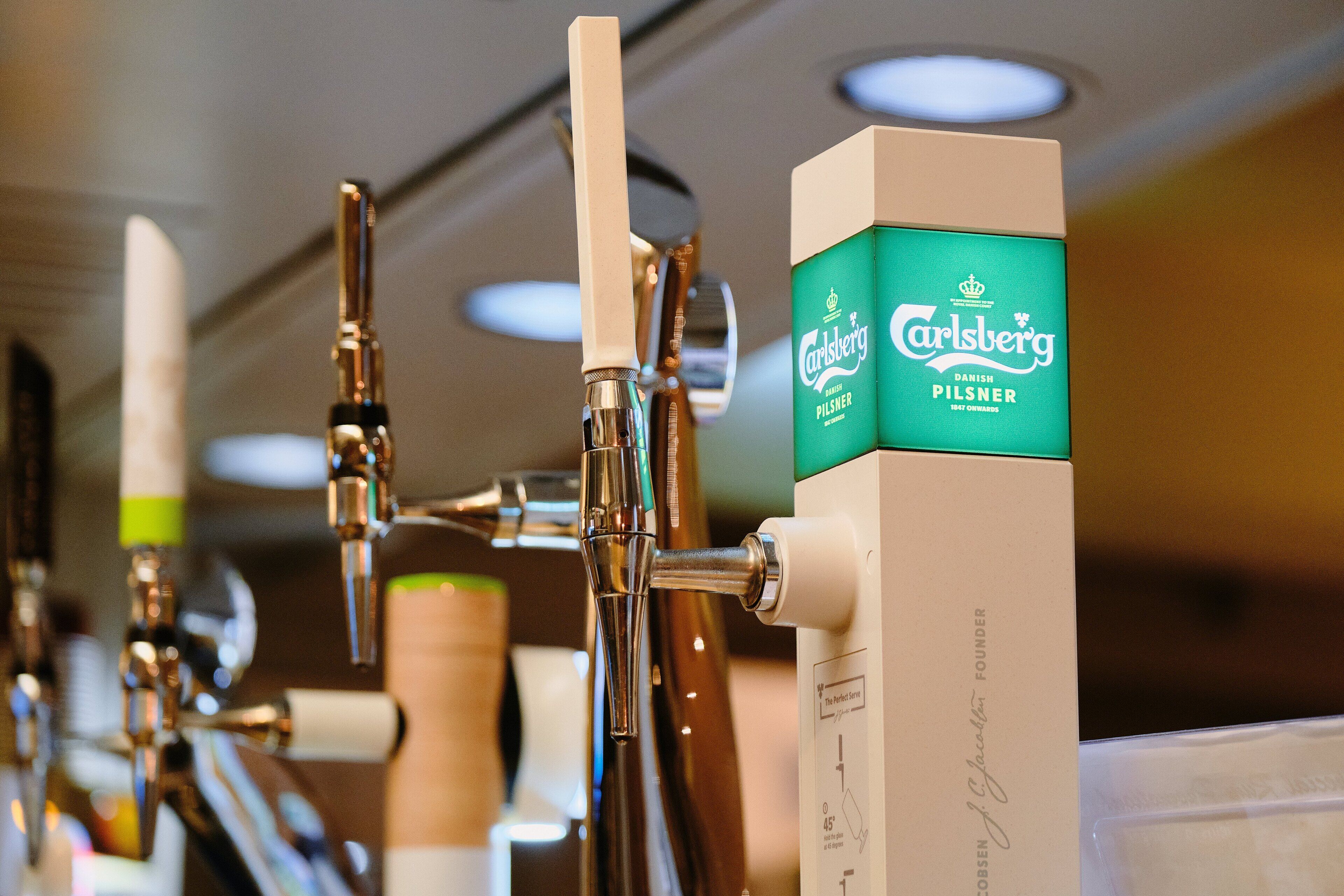 A beer tap station with multiple taps and a Carlsberg beer box.