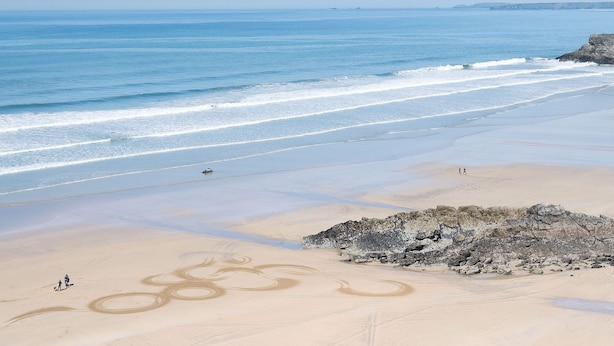 A beach with a clear sky, calm sea, and a sandy area with footprints. - Kilbirnie Hotel (Newquay)