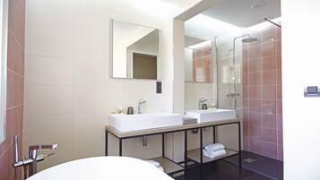 A modern bathroom with two sinks, a large mirror, and a glass shower enclosure.