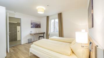 Ein Hotelzimmer mit Bett, Schreibtisch und Stuhl.
