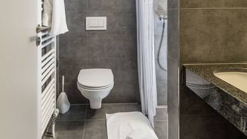 Une salle de bain moderne équipée d’une douche, de toilettes et d’un lavabo.