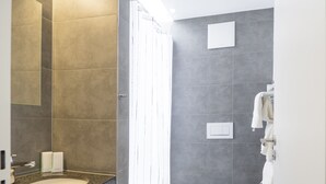 A modern bathroom with a granite countertop, a white sink, a toilet, and a shower curtain. - Hotel & Apartments Bären (Seengen)