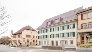 A street view with buildings, a crosswalk, and a clock tower. - Hotel & Apartments Bären (Seengen)