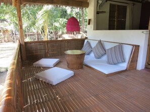 Relax in this serene outdoor seating area with a cushioned bench and round table.