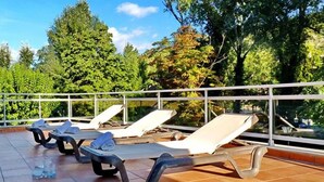 A rooftop terrace with several sun loungers and a railing. - Hotel Balneari de Vallfogona (Vallfogona de Riucorb)