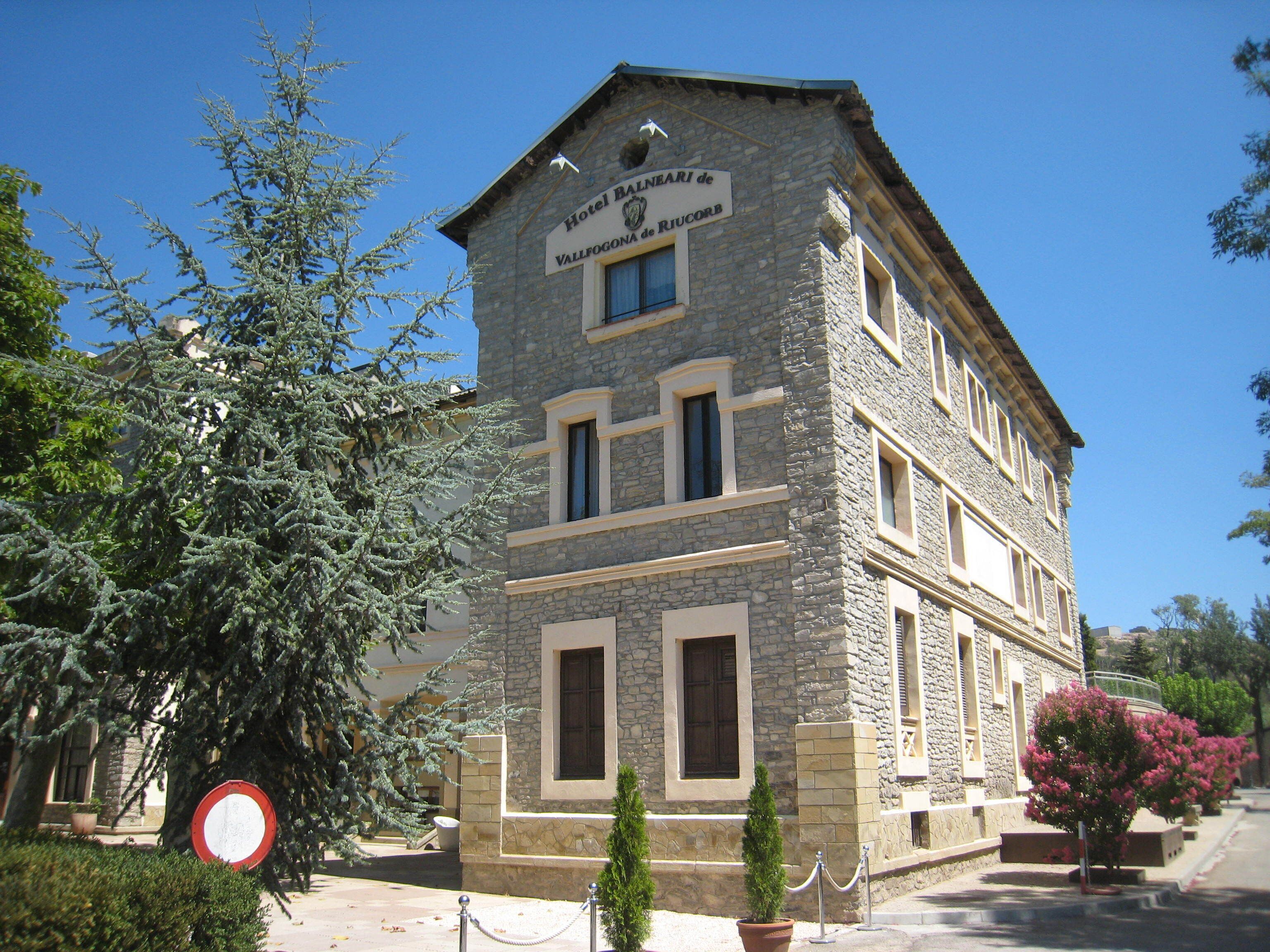 Un edificio de piedra con un letrero que dice 'Hotel Ballneari de Vallfogona de Riucorb'.