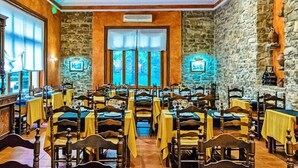 A restaurant with stone walls and wooden furniture, featuring multiple tables and chairs arranged for dining. - Hotel Balneari de Vallfogona (Vallfogona de Riucorb)