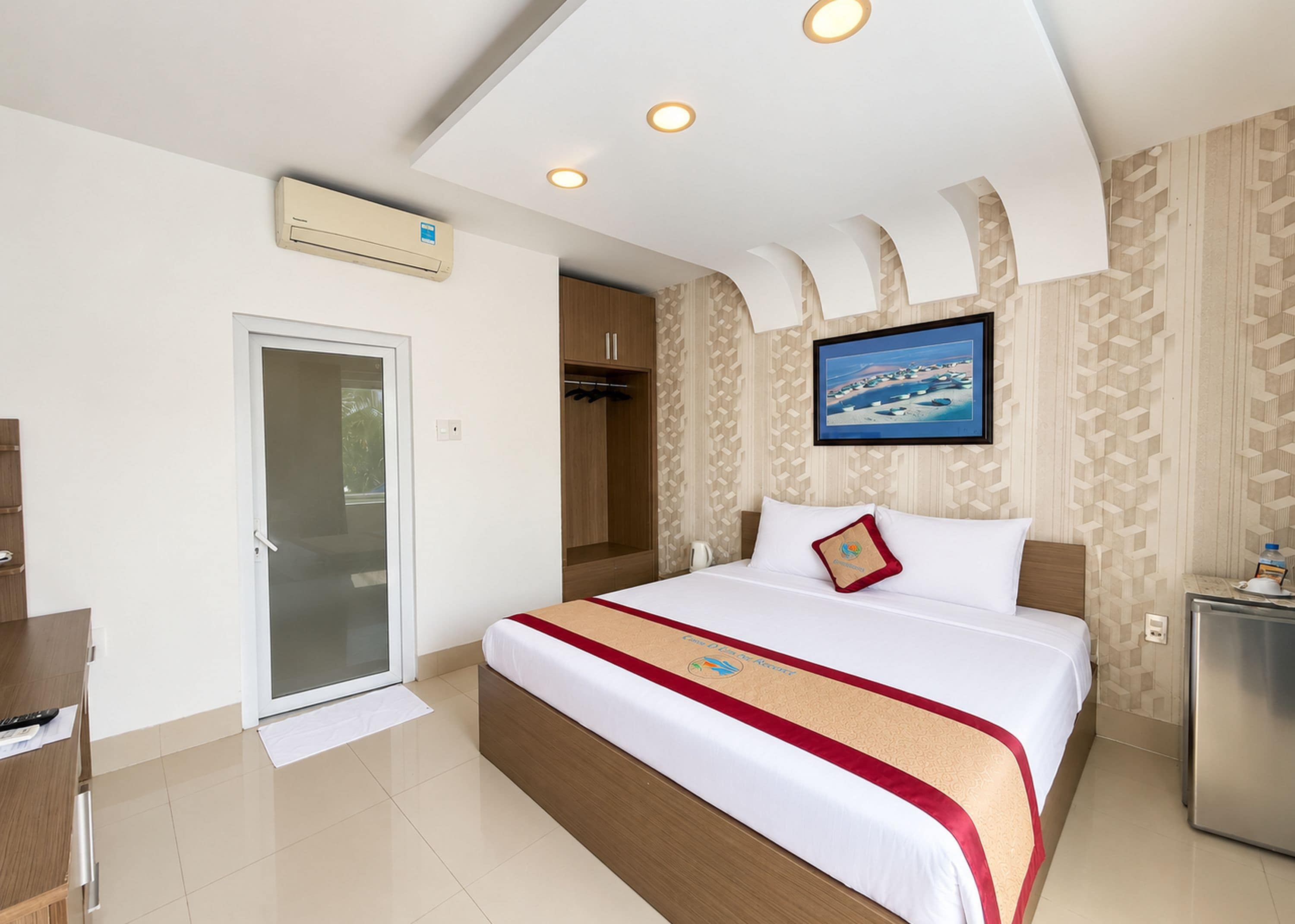 Una habitación de hotel con cama, escritorio, armario y zona de ducha.