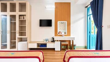 A hotel room with two beds, a wardrobe, a desk with a mirror, a television, and a window with curtains.