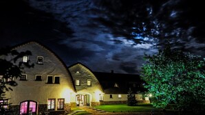 A large, stone building with multiple windows and a well-lit entrance. - HOTelarnia (Puszczykowo)