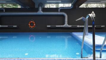 A swimming pool with a lifebuoy, a water slide, and a hot tub.